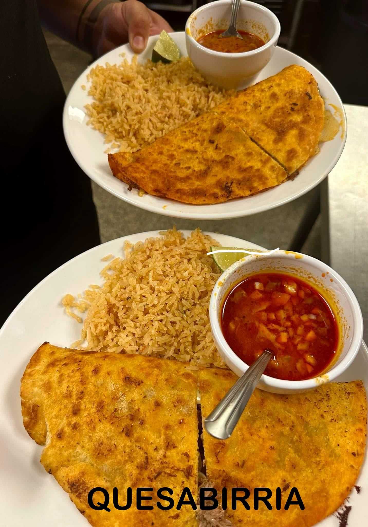 Two plates of quesabirria with rice and a side of broth, served with lime wedges.